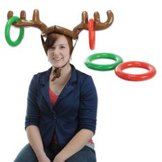 a woman sitting on the ground with an antlers head above her and rings around her