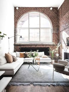 a living room filled with furniture and a large window in the wall above it's windows