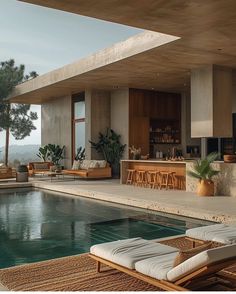 an outdoor pool with lounge chairs and tables next to the swimming pool in front of it