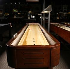 an old fashioned bowling table in the middle of a room