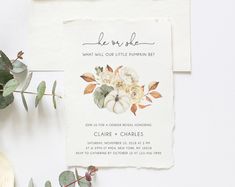 a wedding card with flowers on it next to some greenery and a potted plant