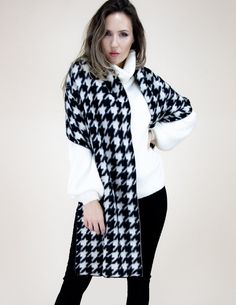 Elevate your style with our Chic Houndstooth Scarf in classic black and white. Made from a soft and warm wool-blend fabric, this scarf adds a touch of sophistication to any outfit. Its timeless houndstooth pattern never goes out of style and complements any color scheme.  At 69.00x20.00 inches, this scarf is versatile in length and can be styled in multiple ways - looped around the neck, draping over the shoulders, or wrapped for extra warmth. It also features delicate fringe detailing, adding a stylish touch to this must-have accessory. Why choose our Houndstooth Scarf? Its elegant design is perfect for any occasion, from a casual day out to a formal event. It also makes for a thoughtful and stylish gift, packaged beautifully and ready to be received with joy. To maintain its softness and Cold Weather Travel, Houndstooth Scarf, Winter Wrap, Winter Shawl, White Fringe, Cozy Scarf, Oversized Scarf, White Houndstooth, Houndstooth Pattern