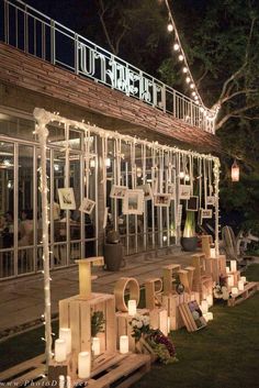 the front of a building with lit up letters and candles