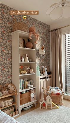 a child's room with toys and bookshelves on the shelves in front of a window