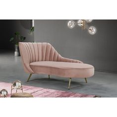 a white couch sitting on top of a pink rug next to a chair and lamp