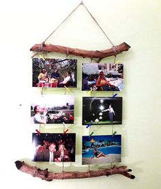 a group of pictures hanging on a wall next to a wooden stick and twig