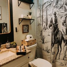 a bathroom with a shower curtain that has a horse and rider drawn on the wall