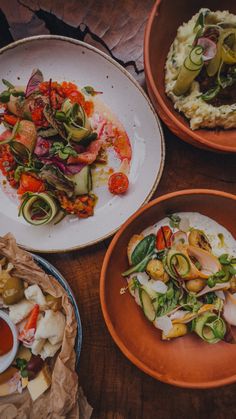 four plates with food on them sitting on a table