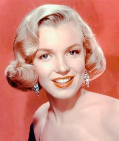 an old photo of a woman with blonde hair and bright orange lipstick on her lips