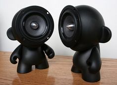 two black speakers sitting on top of a wooden table