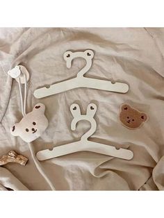 four wooden clothes hangers with teddy bears on them, one is white and the other is brown