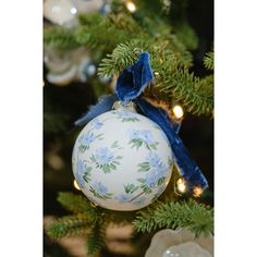 a blue and white ornament hanging from a christmas tree