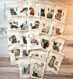 a bunch of cat themed tea towels on a wooden table with numbers and cats in them