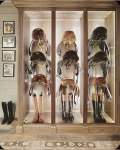 several mannequins wearing boots in a display case with pictures on the wall behind them