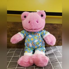 a pink stuffed animal sitting on top of a bed