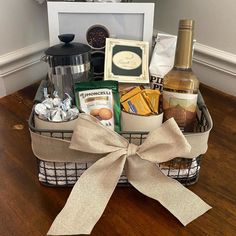 a basket filled with food and wine on top of a wooden floor