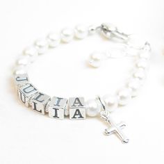 "Real Pearl Name Bracelet for Infant, Baby, or Girl. Created with 5.5mm genuine freshwater pearls, sterling silver block alphabet beads, a heart-shaped lobster clasp with a 1/2\" \"Grow-with-Me\" extender chain, and one sterling silver charm of your choice. Corrugated saucers separate the letters - giving the bracelet textural and visual interest. All metal components are sterling silver. Arrives packaged in my signature high-quality reusable canvas gift bag. Beautiful and ready for gift giving. Personalized White Beaded Bracelets For Baptism, Adjustable Personalized Pearl Bracelet For Baptism, Personalized White Beaded Bracelets For First Communion, Personalized White Bracelet For Confirmation, Personalized White Bracelets For Confirmation, Personalized White Pearl Bracelet For Baptism, Personalized Silver Name Bracelet For Baptism, Personalized White Bracelet For Baptism, Adjustable Silver Name Bracelet For Baptism