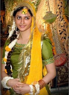 a woman dressed in yellow and green is posing for the camera