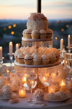 cupcakes and candles are displayed on a table in front of a window at dusk