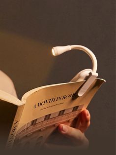 a person reading a book with headphones attached to the book's back end