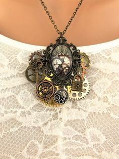 Steampunk Necklace, handmade jewelry by Ralston Originals. I made this steampunk assemblage necklace with a beautifully ornate brass setting, with a large glass steampunk cabochon. To the back of the steampunk setting, I added many different sizes and colors of steampunk gears in brass, silver, copper, and gold metal. I added a small antique gold brass skeleton key charm, a small brass lock charm, and a silver metal clock face charm to the top of the gears. The pendant is 2.5 inches long, and 2. Steampunk Silver Jewelry For Alternative Fashion, Silver Steampunk Jewelry For Alternative Fashion, Steampunk Oc, Steampunk Setting, Steampunk Jewelry Diy, Décor Steampunk, Steampunk Diy Crafts, Jewelry Lock, Men Steampunk