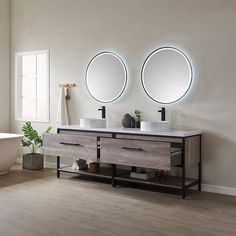 a bathroom with two sinks and mirrors on the wall