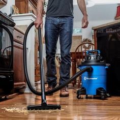 a man is cleaning the floor with a vacuum