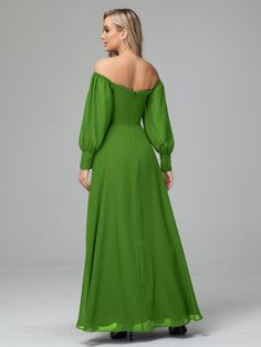 a woman wearing a green dress with long sleeves and an off the shoulder neckline