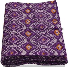 a purple and orange blanket with an intricate design