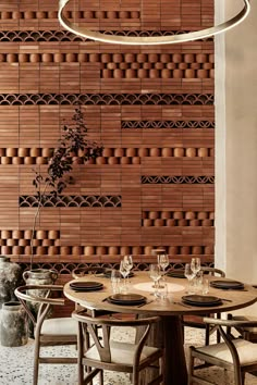 a dining room table with place settings and chairs in front of a wall made out of bricks