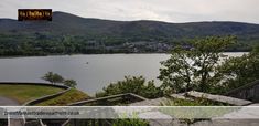 a lake with mountains in the background and stairs leading up to it