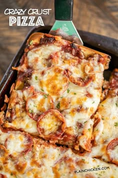 a pan filled with cheesy crust pizza on top of a wooden table next to a spatula