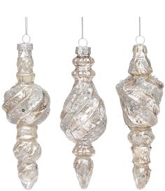 three glass ornaments hanging from strings on a white background, each with different shapes and sizes