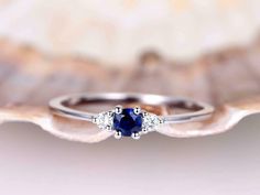 a blue sapphire and diamond ring sitting on top of a shell