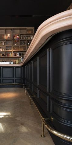 an empty room with black walls and gold trim around the bar area is pictured in this image