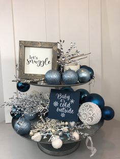 two tiered tray with ornaments and a sign