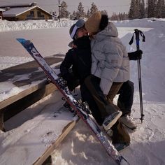 two people sitting on a bench with their skis