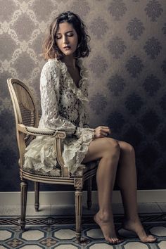 a woman sitting on top of a wooden chair