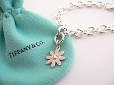 Overview: Here is a gift that she will surely adore! It is shiny, stylish, and super versatile! This piece will make someone REALLY happy! :) Offered for sale is a wonderful Tiffany & Co. Sterling Silver and Pink Enamel Daisy Charm Bracelet. Hanging from its bright Tiffany silver chain is a very pretty Pink Enamel Daisy charm! A classic Tiffany piece that any girl will adore! The Daisy charm hangs from its Sterling Silver Tiffany clasp - it is removable from the bracelet and thus allows you to w Luxury Sterling Silver Charm Bracelet Gift, Luxury Sterling Silver Charm Bracelet As A Gift, Luxury White Gold Charm Bracelet Gift, Designer Bracelets With Polished Finish For Gift, Designer Polished Finish Bracelets For Gift, Elegant Polished Charm Bracelet Gift, Elegant Charm Bracelet As Gift With Polished Finish, Elegant Polished Charm Bracelet As Gift, Elegant Polished Finish Charm Bracelet Gift