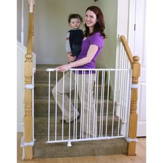 a woman and her son are standing at the top of stairs with a baby gate