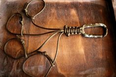 an old pair of scissors sitting on top of a wooden cutting board with rope attached to it