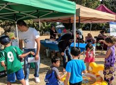 a group of children standing under a tent next to each other