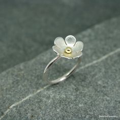 Sterling silver flower ring with central bead. A lovely large 13mm silver flower ring with bead to the centre. on a polished round silver wire band. The central bead can be brass, silver or copper. UK finger sizes  J to T Other sizes on request All my jewellery comes in a presentation gift box.  All my designs are hand made and no two are exactly the same.   Thanks for your time. Flower Shaped Birthstone Ring, Flower Shaped Promise Ring, Flower Shaped Birthstone Promise Ring, Unique 3d Flower Jewelry, Unique 3d Flower Shaped Jewelry, Handmade Delicate Flower Ring, Dainty Flower Ring With Flower Charm, Flower Shaped Promise Ring With Flower Charm, Elegant Sterling Silver Flower Ring With Birth Flower