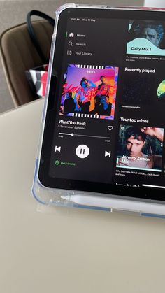 the tablet is sitting on the table with its cover pulled back to show music playing