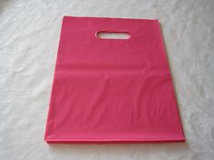 a pink shopping bag sitting on top of a white tablecloth covered floor with paper