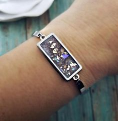 a close up of a person's arm wearing a bracelet with an image of diamonds on it