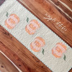 an orange and white table runner with pumpkins on it