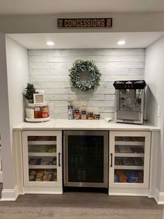 a kitchen with white cabinets and an open refrigerator in the center, filled with food