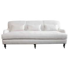 a white couch with four pillows on it's back and two armrests