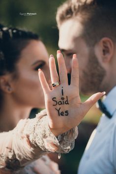 a man and woman holding up their hand with the words i said yes written on it